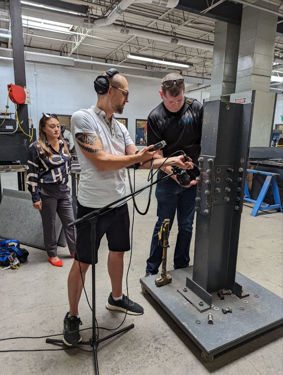 Tim Penner with field recorder and headphones capturing audio at a VR training simulation site