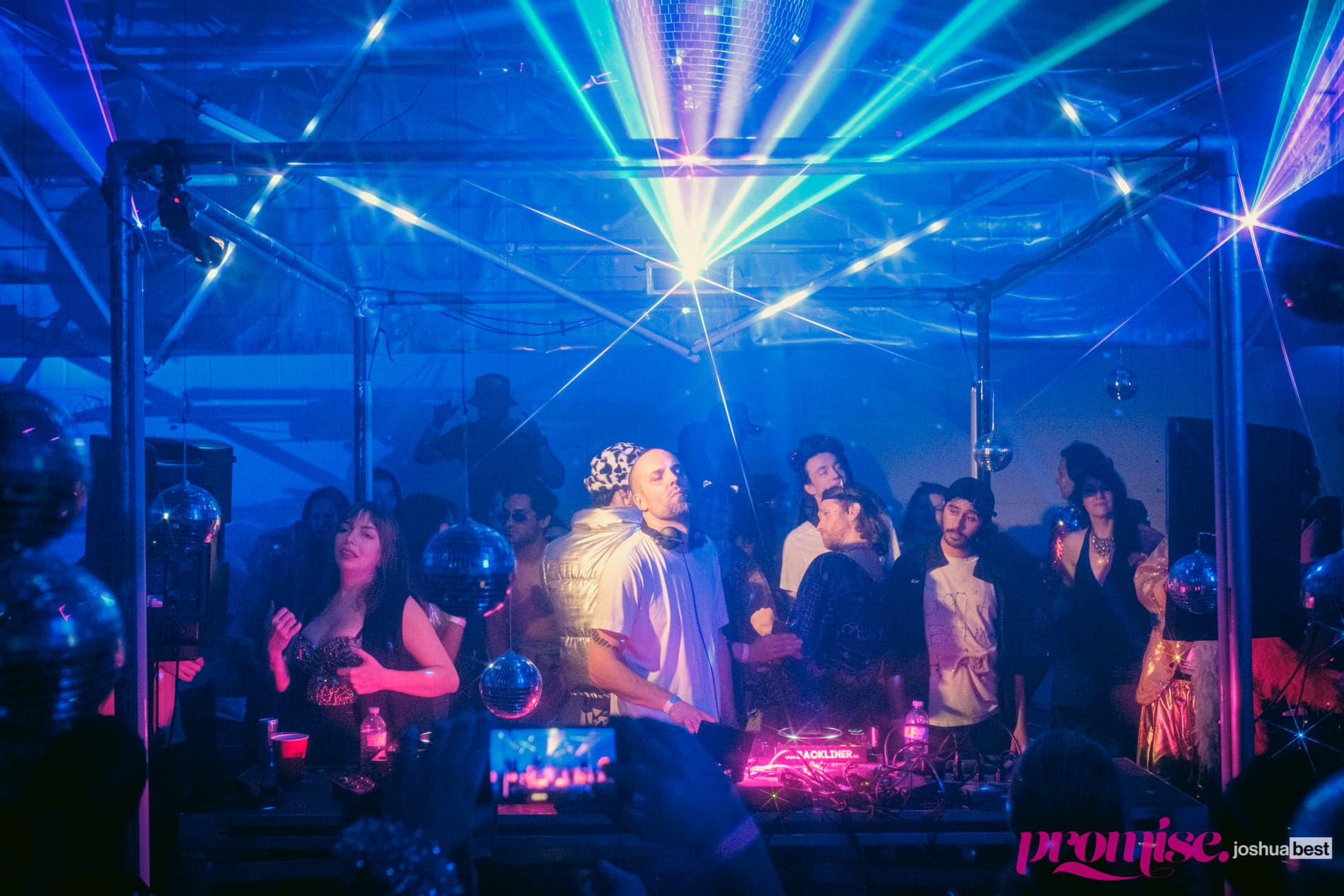 Tim Penner at the booth surrounded by dancers, disco balls and lasers, Promise Toronto
